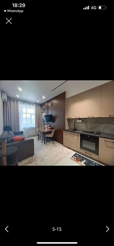 Современная студия с полноценной кухней и отдельной гостиной зоной -