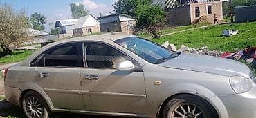 Седан серебристого цвета, 4 двери, кузов классического типа. Литые