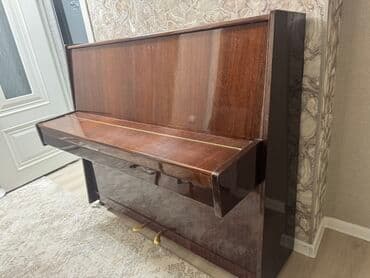 Пианино с полированной деревянной поверхностью и глянцевым блеском