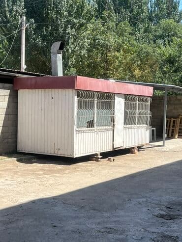 Квартиры: Киоск из белых панелей с красной крышей и металлическими решетками на — 1