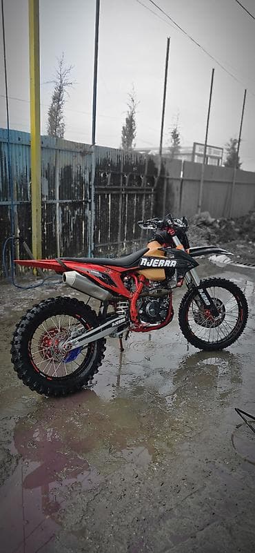 м параллель: Мотоцикл эндуро AJERRA (брендовая наклейка на пластике). Описание: - — 1