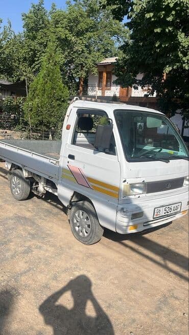 домкрат для автомобиля: Белый пикап Daewoo лабо открытым кузовом. Автомобиль оснащен четырьмя — 1
