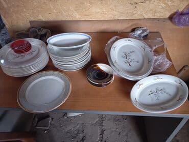 набор столовых приборов: Набор разнообразной посуды, включающий круглые, овальные тарелки и — 1