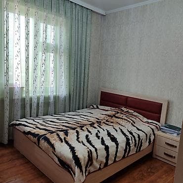 Двуспальная кровать с деревянным каркасом и мягким изголовьем