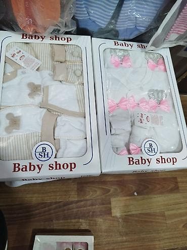 Два набора детской одежды, представленные в подарочных коробках. Один