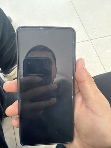 Смартфон с плоским дисплеем и центральным вырезом под фронтальную