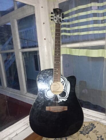 Акустическая гитара черного цвета с вырезом и белым рисунком в виде