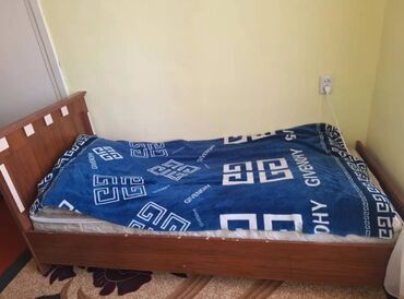 кровать из дерево: Деревянная кровать с прямоугольным изголовьем. Матрас покрыт синим — 1