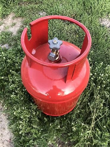 Красный газовый баллон среднего размера, оснащенный вентилем с