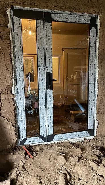 Двухсекционная балконная дверь черного цвета с матовой отделкой рамы и