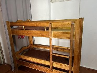 Двухъярусная деревянная кровать из массива (похоже на сосну). -