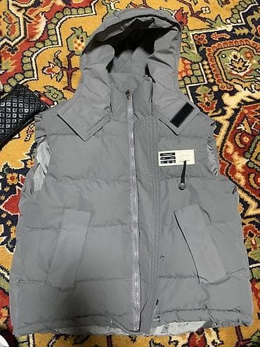 жилетк: Серая утеплённая жилетка с капюшоном. Особенности: - Прямой крой — 1