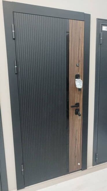 Входная дверь с отделкой под дерево и вертикальными полосами. Черная