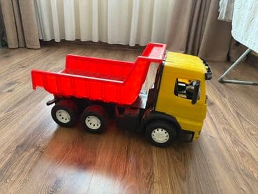 Игрушечный самосвал ярко-желтого цвета с красным откидным кузовом