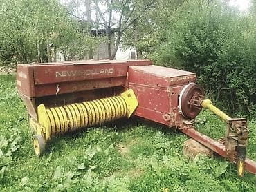Пресс-подборщик New Holland модели 975, предназначенный для сбора и