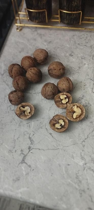 Грецкий орех в скорлупе - Цельные орехи, часть показана расколотой —