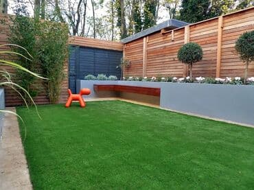 цена искусственного газона для футбольного поля: Уютный задний двор с зеленой лужайкой из искусственной травы. Высокие — 1