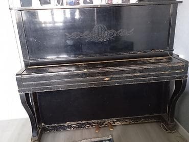 Пианино вертикальное, корпус черного цвета с резным орнаментом на