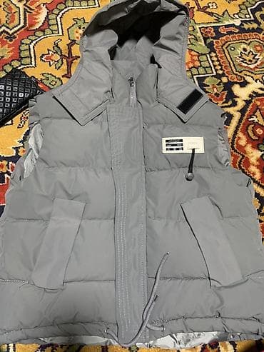 жилетк: Серая утеплённая жилетка с капюшоном. Особенности: - Прямой крой — 2