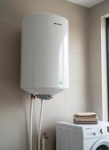 Белый цилиндрический водонагреватель с компактным корпусом. Подходит