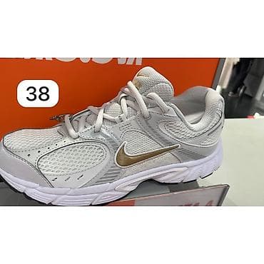38: Кроссовки Nike (модель в беговом стиле) — белые с золотым Swoosh. - — 2