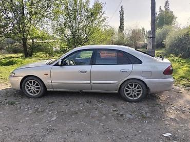 керме тоо: Mazda 626: 1999 г., 1.8 л, Кол менен иштөөчү, Бензин, Седан — 5