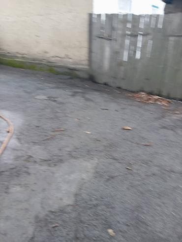 строительные блоки: Дом из шлакоблока с односкатной крышей из волнистых листов. Стены — 9