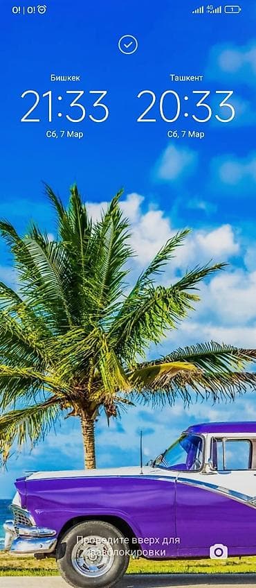 Смартфон с экраном блокировки, показывающим два часовых пояса