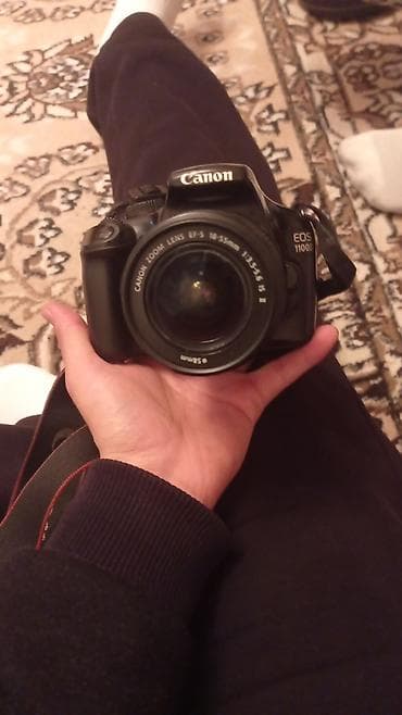 Видеокамеры: Зеркальная фотокамера Canon EOS 1100D с комплектным объективом Canon — 1
