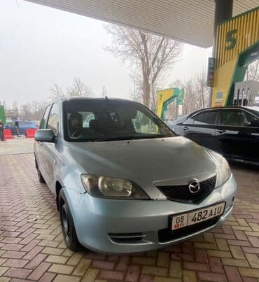 мазда демио передний бампер: Хэтчбек Mazda 2 в светлом оттенке с заметными черными наклейками в — 2