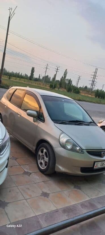 машина экономичный: Хэтчбек Honda Fit в золотистом цвете, оснащенный литыми дисками — 2
