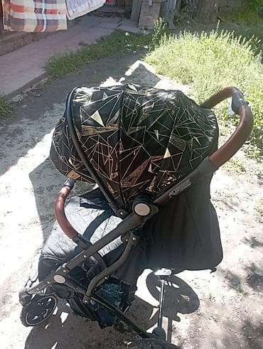 Прогулочная коляска с большим капюшоном и кожаными вставками на