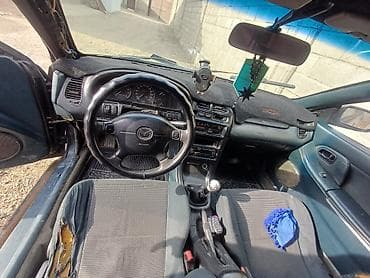Mazda 323 (кузов BJ) — салон и оборудование - Руль с эблемой Mazda