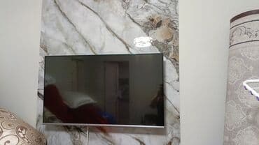 Телевизор с тонкими рамками, диагональ примерно 40–43". Плоская