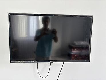 Телевизор LG, диагональ около 32–37" (по габаритам на стене). Плоская