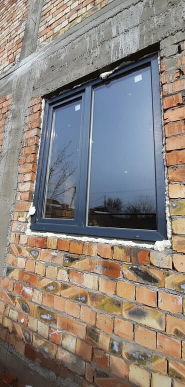 облицовка дома: Двухсекционное пластиковое окно серого цвета. Окно имеет две секции и — 1