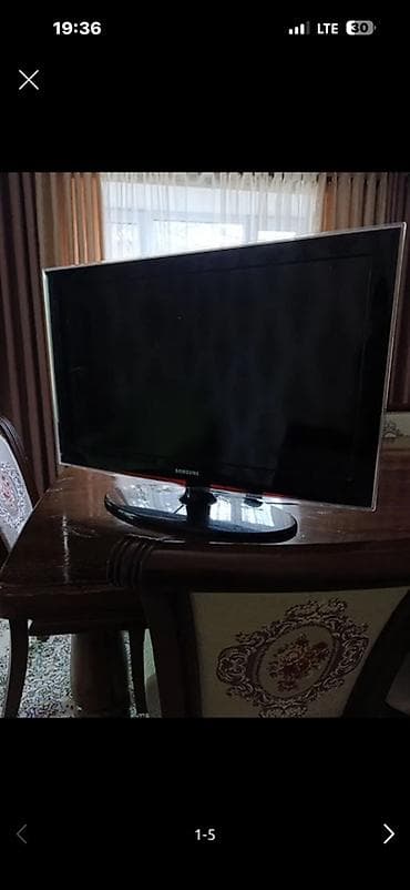 Телевизор Samsung с плоским экраном на настольной подставке. -