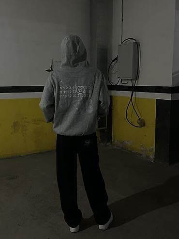 Серое худи оверсайз с капюшоном и принтом на спине. Модель выполнена — 1