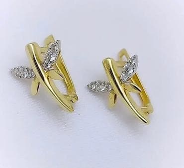 серьги с бриллиантом: Пара элегантных золотистых сережек с английским замком. Каждая сережка — 7