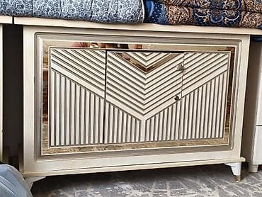 Комод с тремя дверцами, выполненный в светлом цвете с элементами под