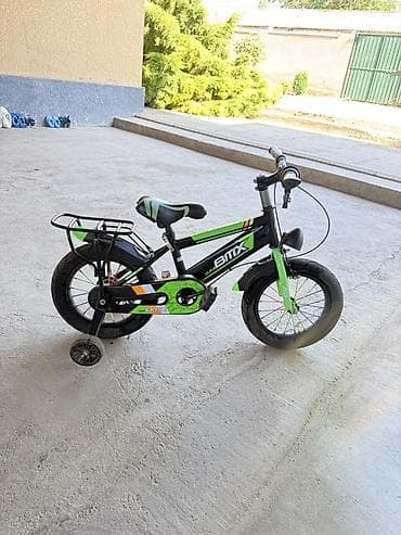 Детский велосипед BMX, размер колёс примерно 14". Яркий чёрно‑зелёный