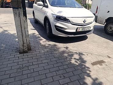 Электромобиль (кроссовер/MPV) белого цвета с 3 рядами сидений и