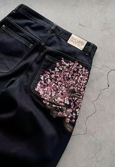 Джинсы из плотного темно‑индигового денима с вышивкой сакуры. -