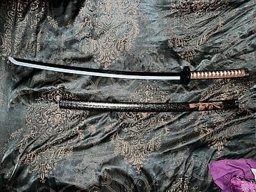 меч саске: Представлена катана с черным клинком и черными ножнами, украшенными — 1