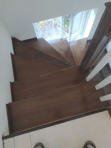 Деревянная лестница с окрашенными ступенями и белыми балясинами