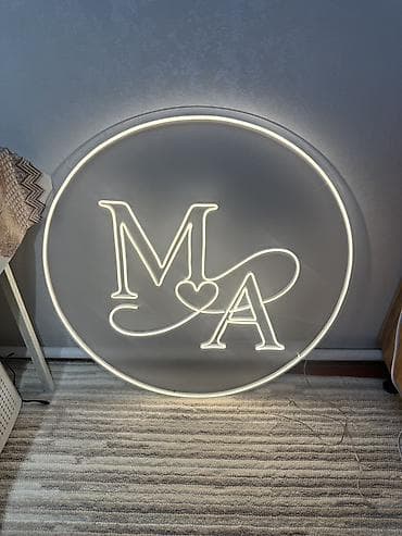 Неоновая LED-вывеска в виде круглой таблички с инициалами «M ♥ A». -