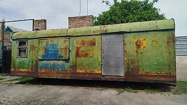 Передвижной киоск/вагончик из металла (примерно 6–7 м длиной). Корпус
