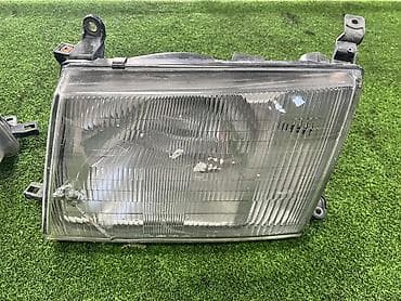 грузовики ош: Левая передняя фара Тойота Ленд круизер 105 (до рест) Оригинал — 1
