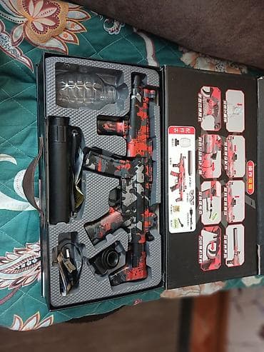 Игрушечный автомат в красно-чёрном камуфляжном стиле. Оснащён