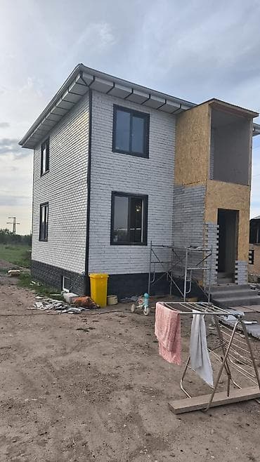 Двухэтажный загородный дом с мансардной крышей и современным фасадом